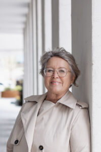 Frau mit Brille in hellem Mantel
